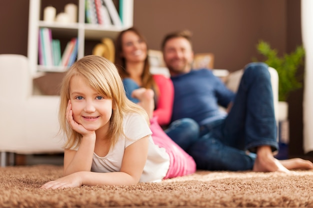 Portrait de jeune fille souriante se détendre avec ses parents à la maison