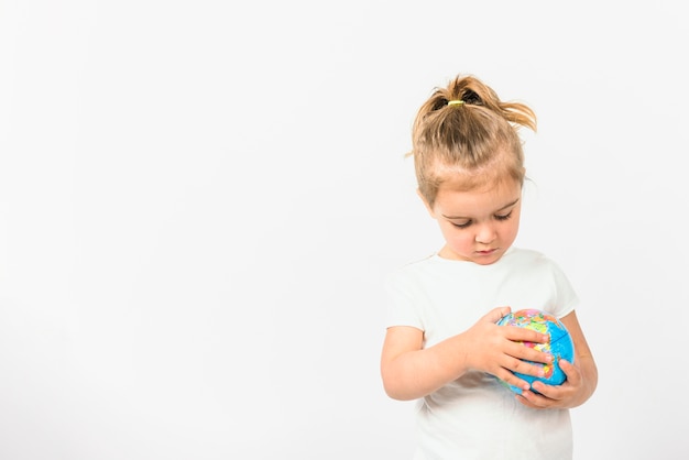 Portrait d&#39;une jeune fille tenant une boule de globe sur fond blanc