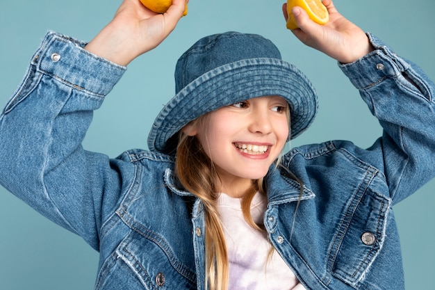 Photo gratuite portrait de jeune fille tenant un citron en tranches