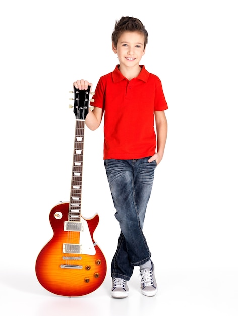 Portrait de jeune garçon avec guitare électrique - isolé sur mur blanc