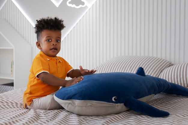 Portrait de jeune garçon jouant avec son jouet en peluche