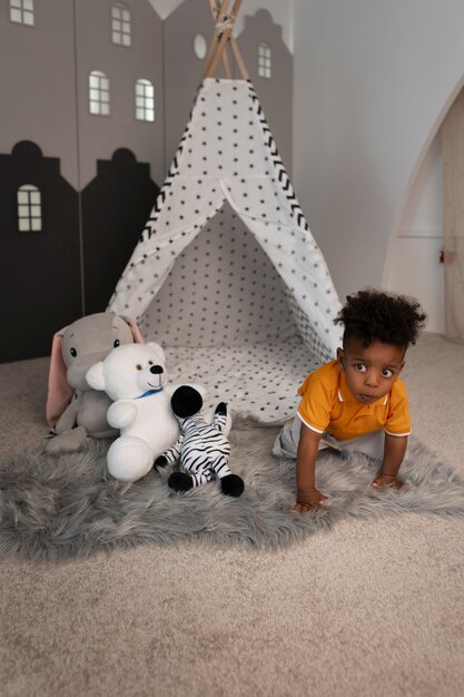 Portrait de jeune garçon jouant avec son jouet en peluche