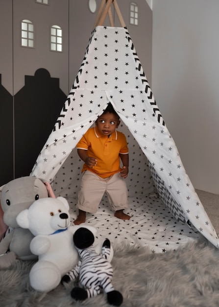 Photo gratuite portrait de jeune garçon jouant avec son jouet en peluche