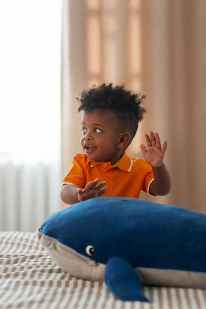 Portrait de jeune garçon jouant avec son jouet en peluche