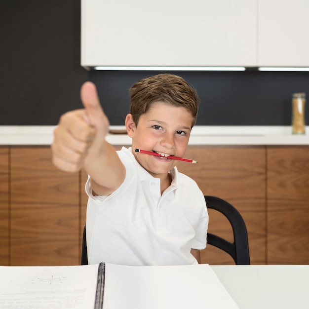 Portrait de jeune garçon montrant les pouces vers le haut