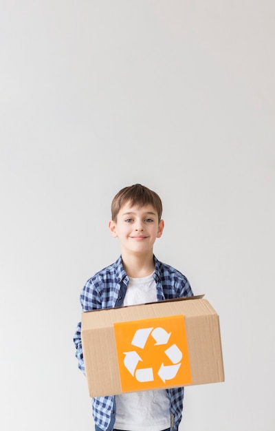 Portrait de jeune garçon tenant la boîte de recyclage