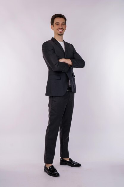 Portrait de jeune homme d'affaires beau portant costume debout avec les bras croisés avec isolé sur fond blanc studio