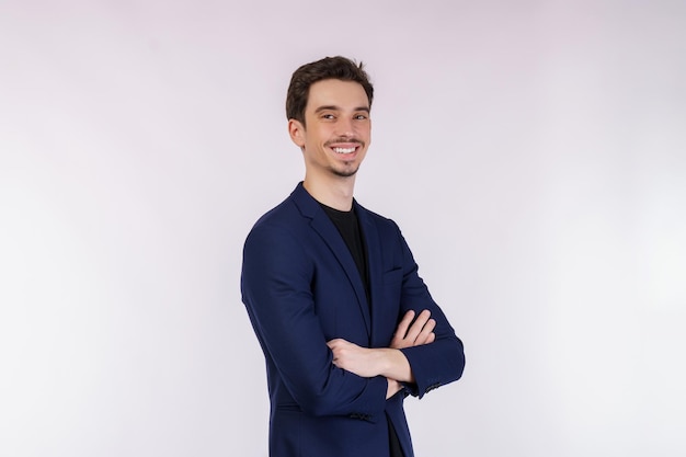 Portrait de jeune homme d'affaires beau portant costume debout avec les bras croisés avec isolé sur fond blanc studio