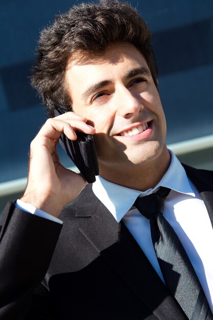 Portrait d&#39;un jeune homme d&#39;affaires parlant avec un smartphone