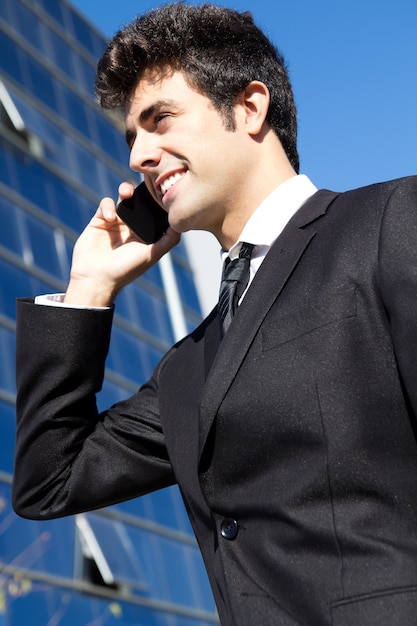 Portrait d&#39;un jeune homme d&#39;affaires parlant avec un smartphone