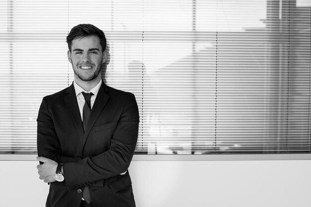 Portrait de jeune homme d'affaires souriant à l'aéroport avec costume