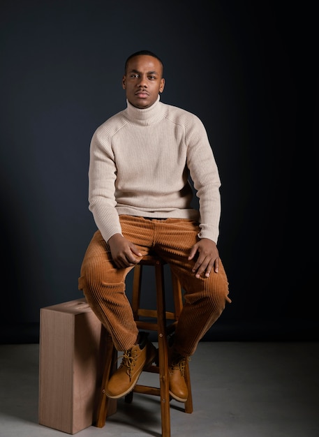 Portrait jeune homme africain assis sur une chaise