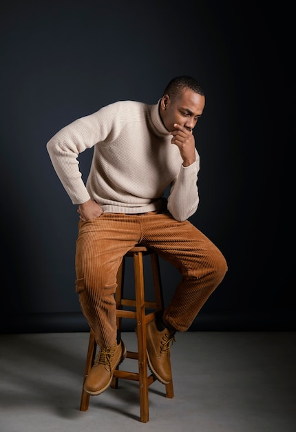 Portrait jeune homme africain assis sur une chaise