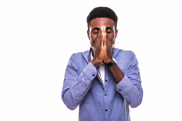 Portrait de jeune homme afro-américain en chemise à carreaux couvrant sa bouche avec les deux mains et regardant avec expression choquée et coupable comme s'il avait fait quelque chose de mal, debout au tableau blanc