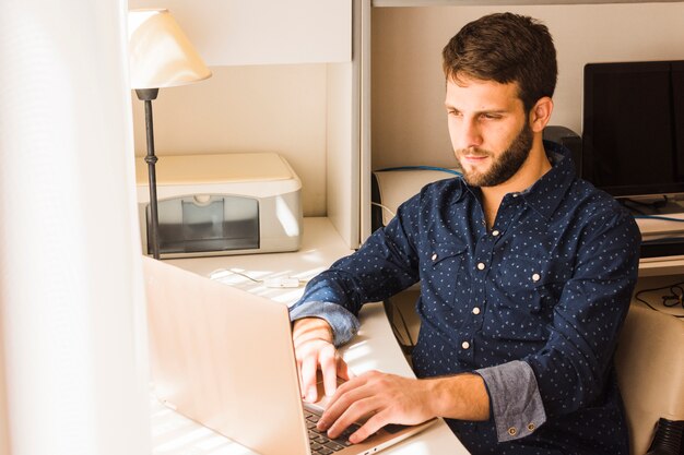 Portrait d&#39;un jeune homme à l&#39;aide d&#39;une tablette numérique