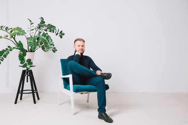 Portrait d&#39;un jeune homme assis sur une chaise dans un bureau