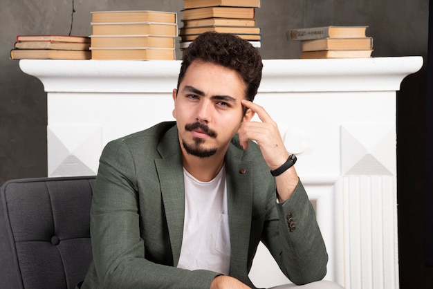 Portrait de jeune homme assis sur une chaise une pensée.