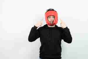 Photo gratuite portrait de jeune homme athlétique au chapeau de boxe rouge debout.