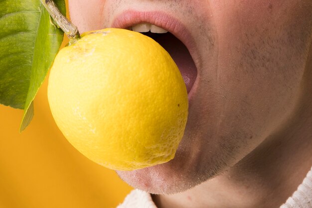 Portrait de jeune homme au citron dans une scène jaune