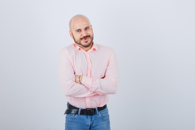 Photo gratuite portrait d'un jeune homme aux bras croisés