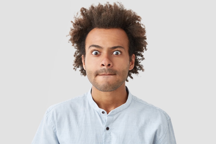 Photo gratuit portrait de jeune homme aux cheveux bouclés portant chemise
