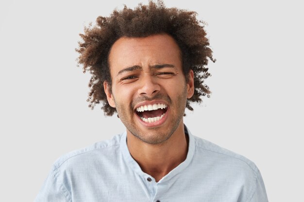 Portrait de jeune homme aux cheveux bouclés portant chemise