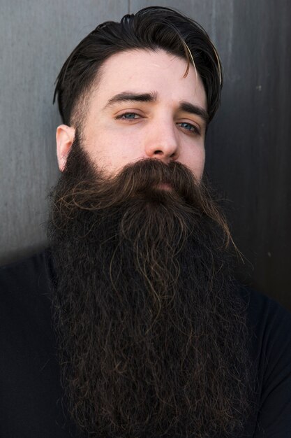 Portrait d&#39;un jeune homme barbu sur fond gris