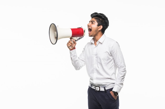 Portrait de jeune homme beau crier à l'aide d'un mégaphone isolé sur mur blanc