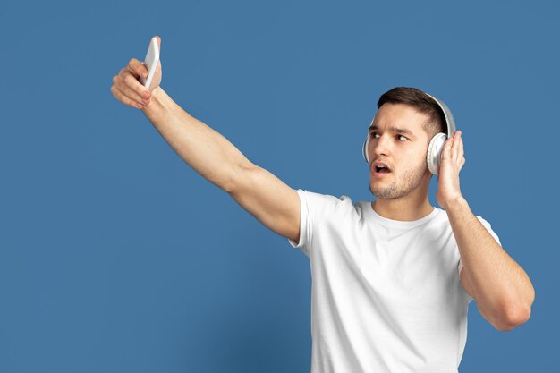 Portrait de jeune homme caucasien sur bleu