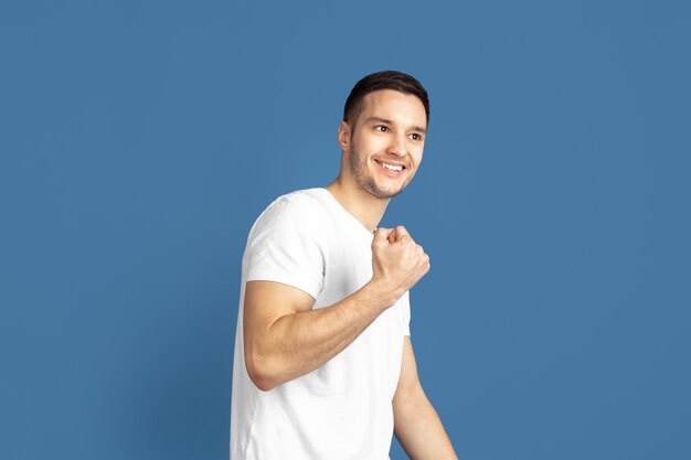 Portrait de jeune homme caucasien sur mur bleu