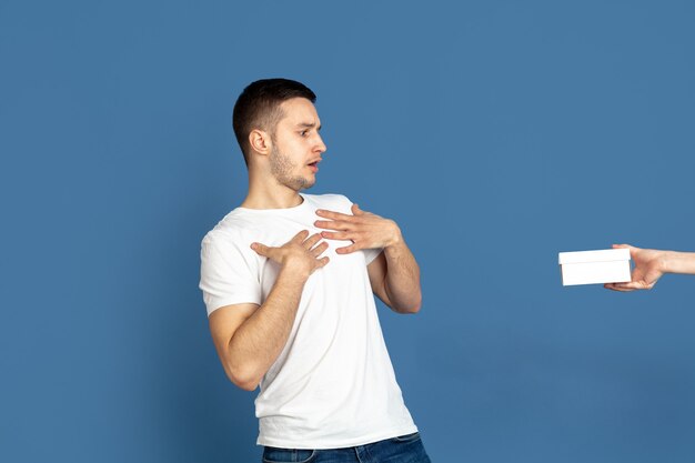 Portrait de jeune homme caucasien sur mur bleu