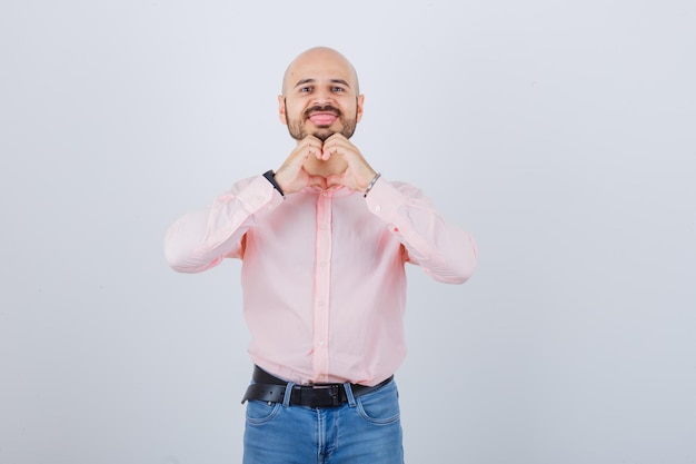 Portrait d'un jeune homme confiant montrant le geste du coeur