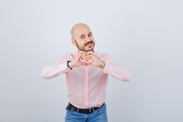 Portrait d'un jeune homme confiant montrant le geste du coeur