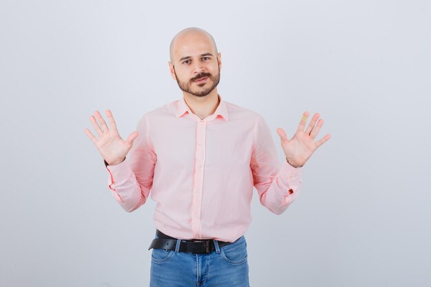 Portrait d'un jeune homme confiant montrant des palmiers