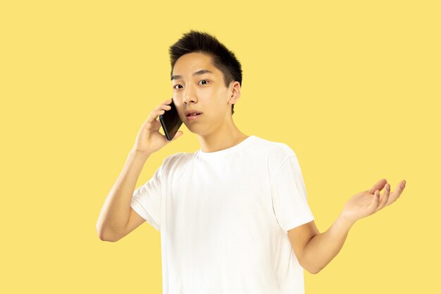 Portrait de jeune homme coréen isolé sur studio jaune.