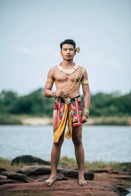 Portrait de jeune homme en costume traditionnel posant dans la nature en Thaïlande