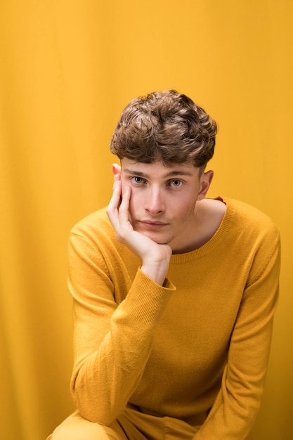 Photo gratuite portrait d'un jeune homme dans une scène jaune