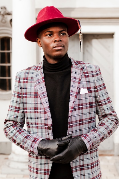 Photo gratuite portrait d'un jeune homme élégant avec un chapeau moderne