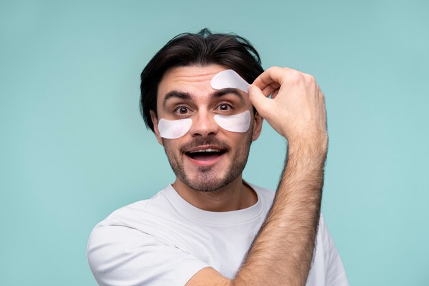 Portrait d'un jeune homme enlevant les taches sous les yeux de son front