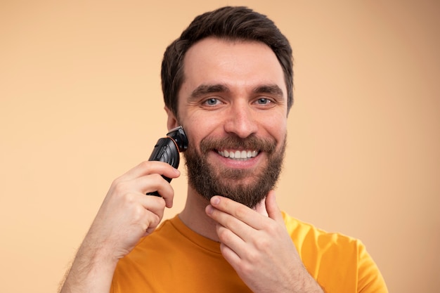 Portrait d'un jeune homme excité se rasant la barbe