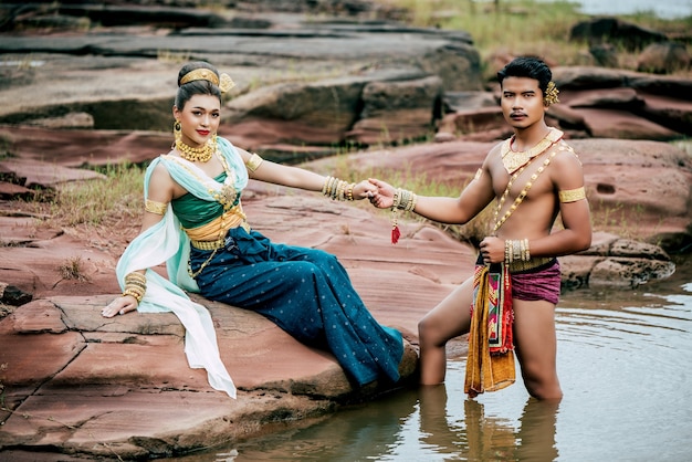 Portrait de jeune homme et femme portant de beaux costumes traditionnels posent dans la nature en Thaïlande