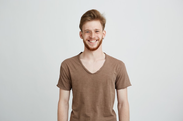 Portrait de jeune homme gai heureux avec barbe souriant.