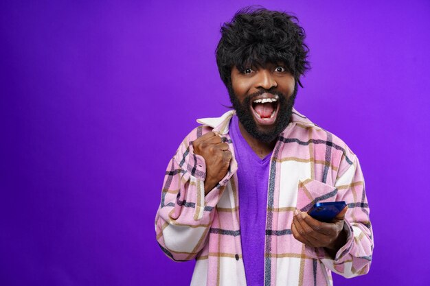 Portrait d'un jeune homme heureux et heureux avec un téléphone portable