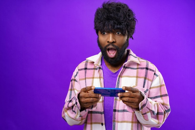 Portrait d'un jeune homme heureux et heureux avec un téléphone portable