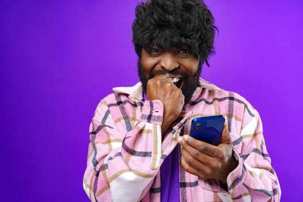 Portrait d'un jeune homme heureux et heureux avec un téléphone portable