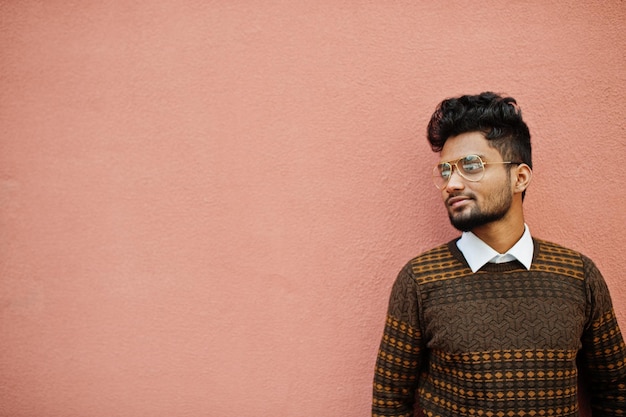 Photo gratuite portrait de jeune homme indien élégant modèle à lunettes isolé sur fond de mur rose