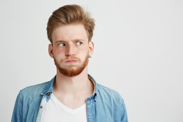 Portrait D'un Jeune Homme Nerveux Avec Barbe Portant Une Chemise En Jean à Côté.