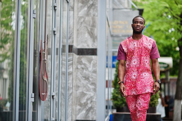 Portrait d'un jeune homme noir portant des vêtements colorés rouges traditionnels africains