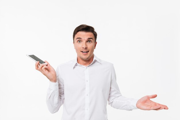 Portrait d'un jeune homme perplexe dans une chemise blanche