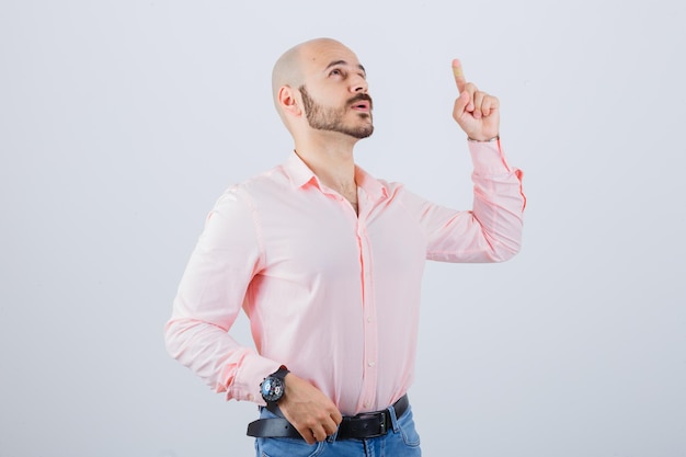 Portrait de jeune homme pointant vers le haut